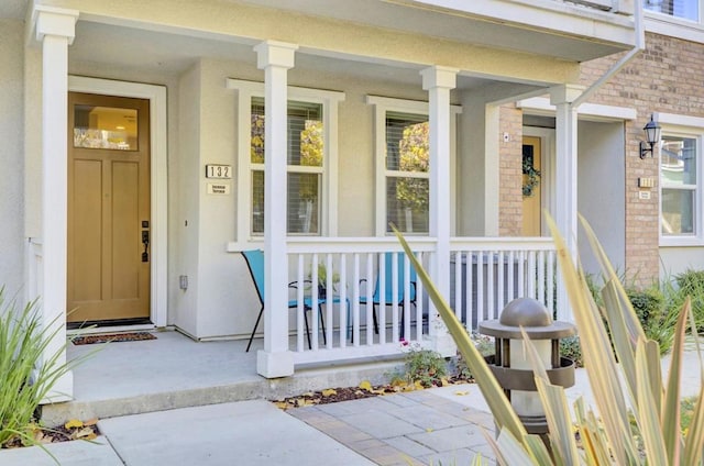 view of exterior entry featuring covered porch