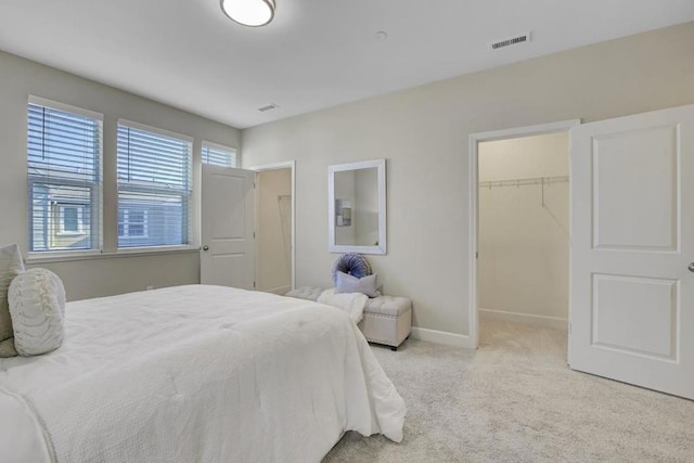 carpeted bedroom featuring a spacious closet and a closet