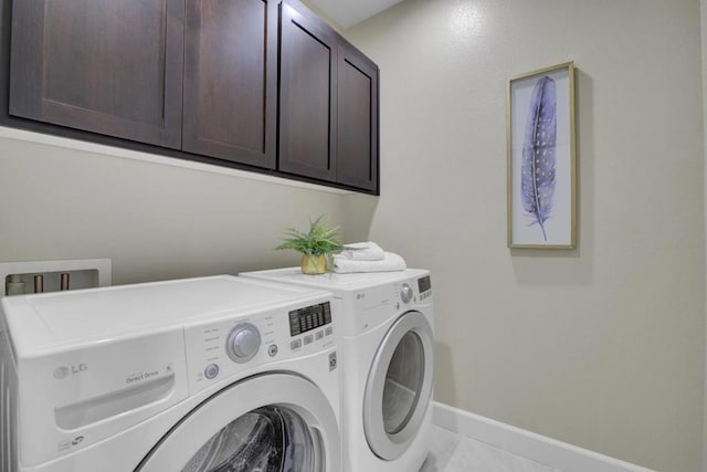 clothes washing area featuring cabinets, independent washer and dryer, and light tile patterned floors