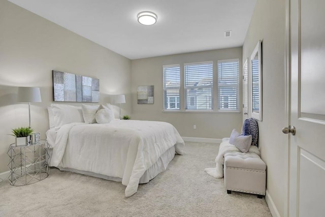 bedroom with multiple windows and light carpet