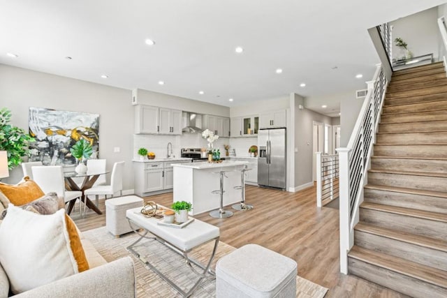 living room with light hardwood / wood-style floors and sink