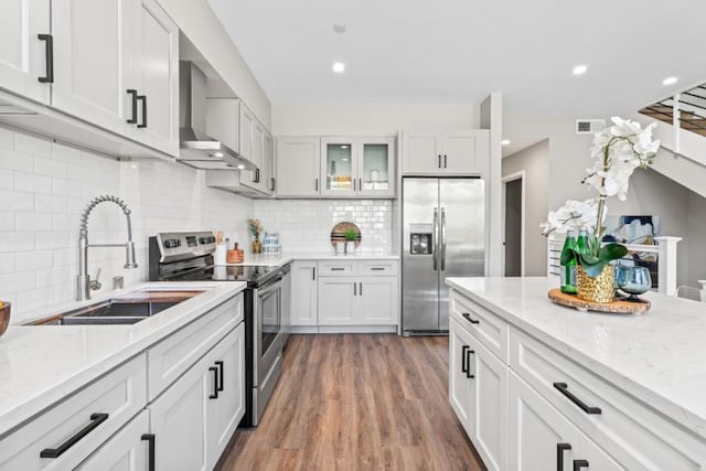 kitchen with white cabinetry, sink, wall chimney exhaust hood, tasteful backsplash, and appliances with stainless steel finishes