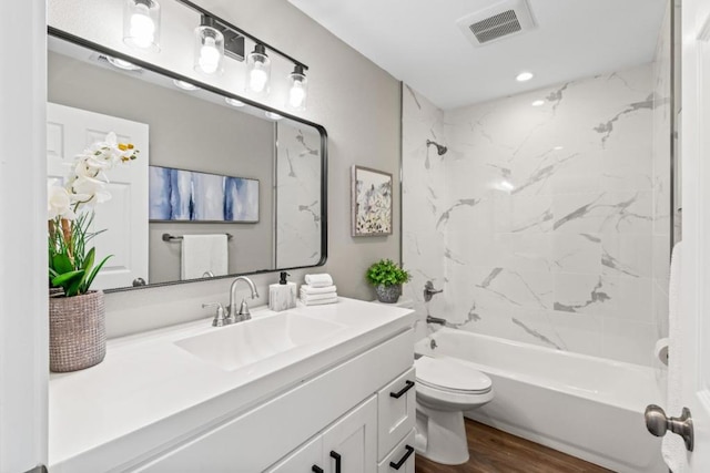 full bathroom with vanity, toilet, wood-type flooring, and tiled shower / bath