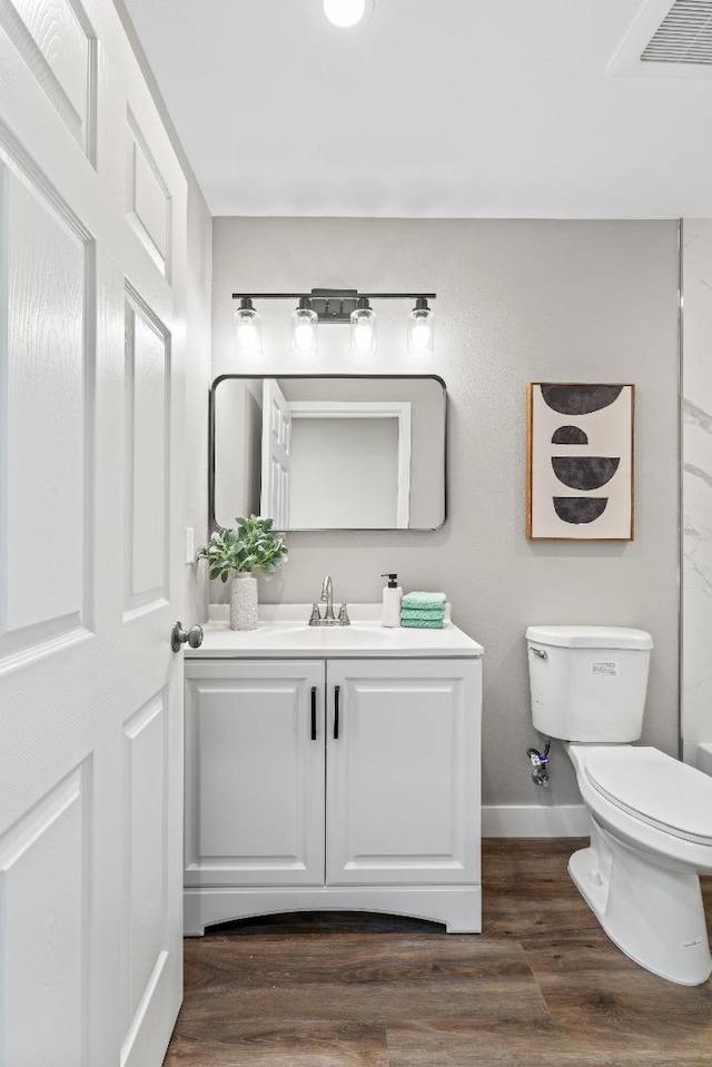 bathroom featuring vanity, hardwood / wood-style flooring, and toilet