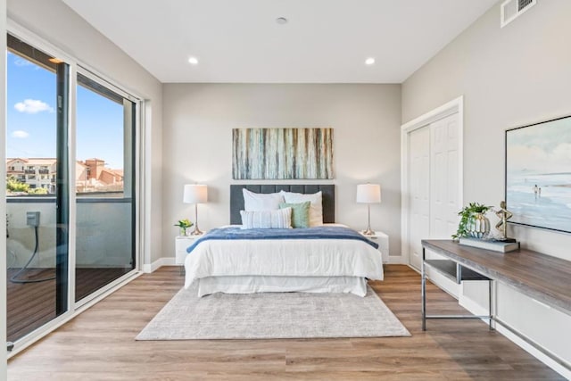 bedroom with hardwood / wood-style floors, access to outside, and a closet