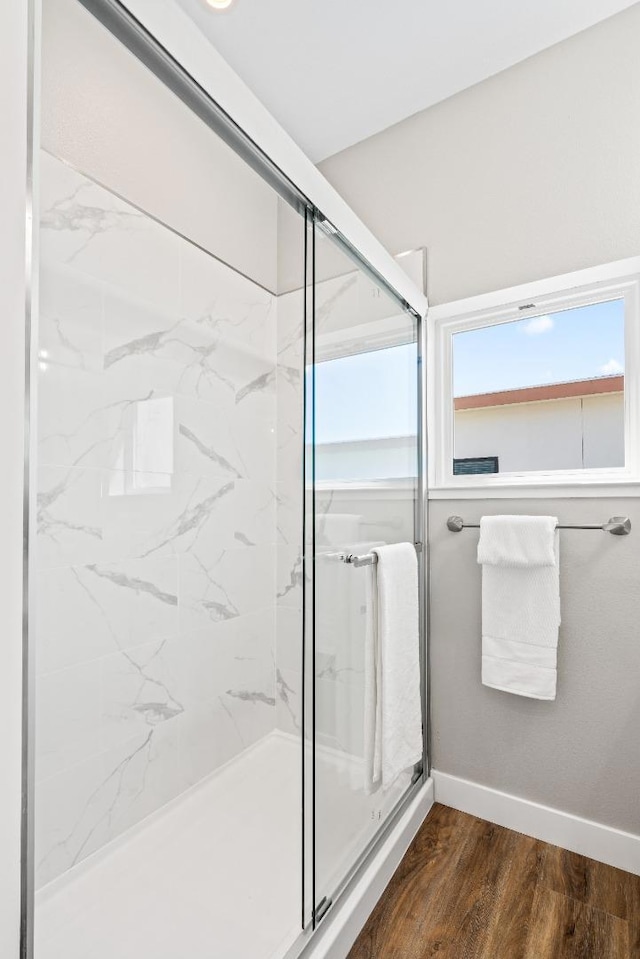 bathroom with hardwood / wood-style floors and a shower with shower door