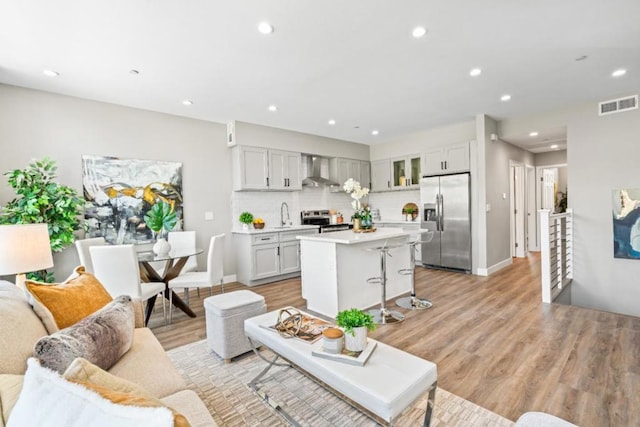 living room with sink and light wood-type flooring