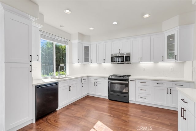 kitchen featuring dark wood-type flooring, white cabinets, appliances with stainless steel finishes, and sink