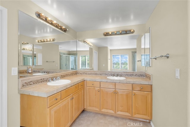 bathroom with a shower with shower door, vanity, and decorative backsplash