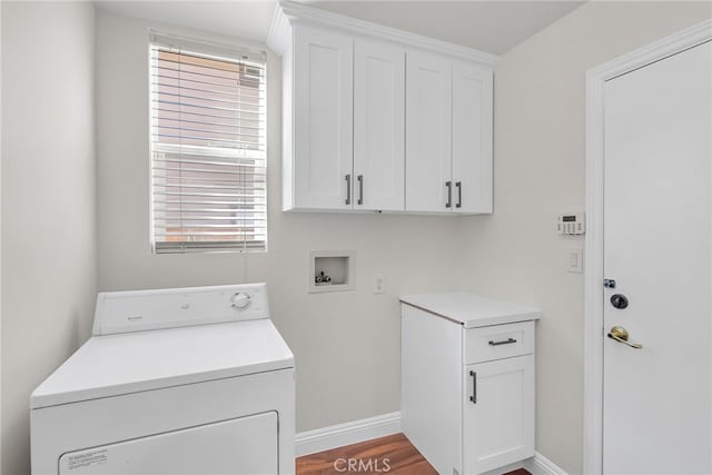 washroom with washer / clothes dryer, light hardwood / wood-style floors, and cabinets