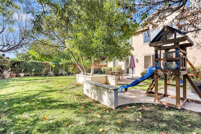 view of play area with a lawn and a patio