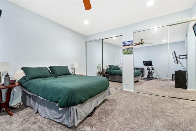 carpeted bedroom with two closets and ceiling fan