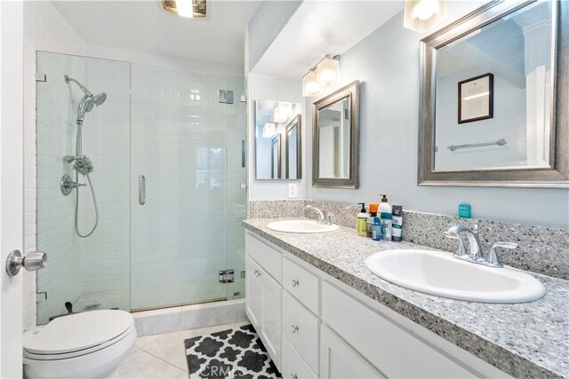 bathroom with tile patterned flooring, vanity, toilet, and walk in shower