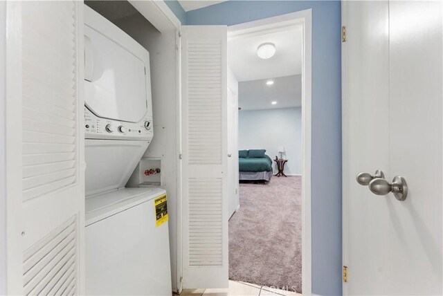 washroom with light carpet and stacked washer and dryer