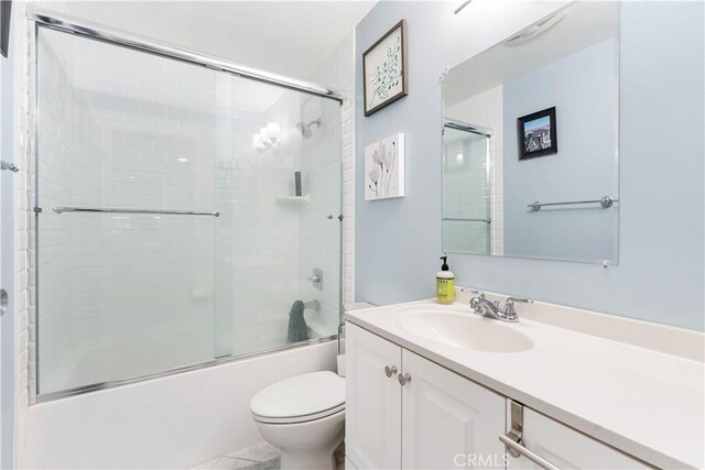 full bathroom with vanity, toilet, and enclosed tub / shower combo