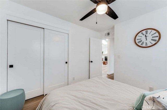 bedroom featuring ceiling fan, dark hardwood / wood-style flooring, and a closet