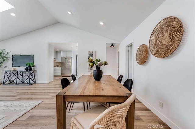 dining area featuring light wood-type flooring and lofted ceiling