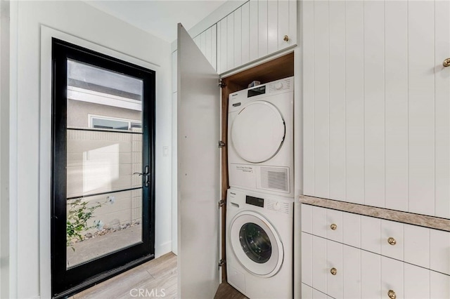 washroom with light wood-type flooring and stacked washing maching and dryer