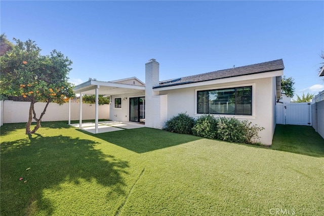 rear view of house featuring a yard and a patio