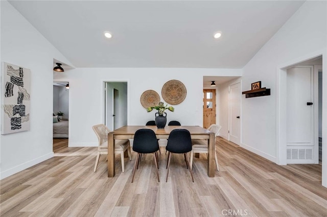 dining room with light hardwood / wood-style floors and vaulted ceiling