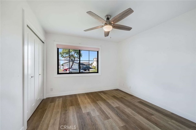 unfurnished bedroom featuring ceiling fan, a closet, and hardwood / wood-style floors