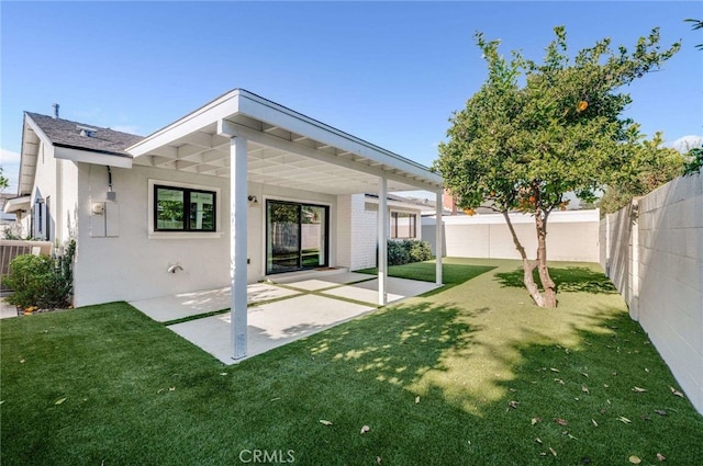 back of house featuring a patio and a lawn