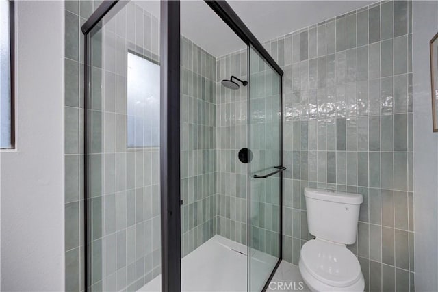 bathroom featuring toilet and an enclosed shower