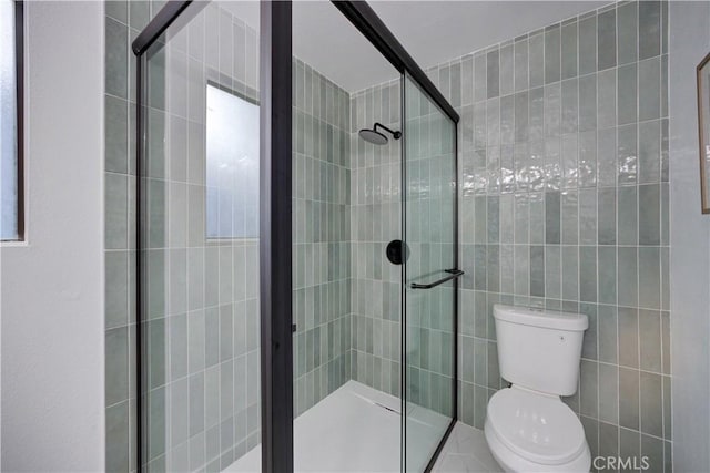 full bathroom with a shower stall, toilet, and tile walls