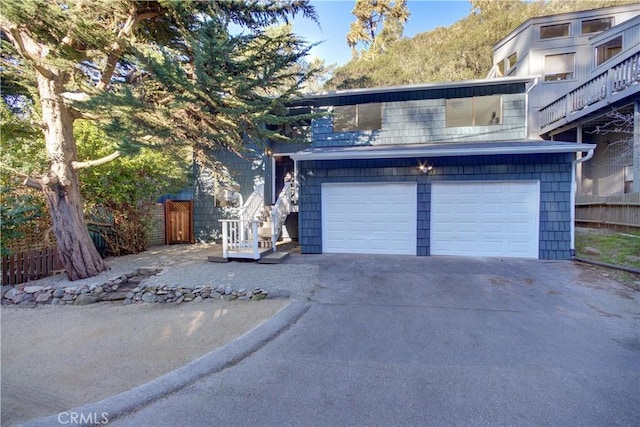 garage featuring driveway and fence