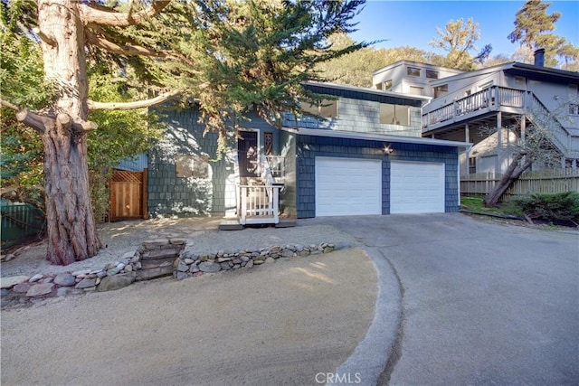 view of front of property featuring a garage, fence, and concrete driveway