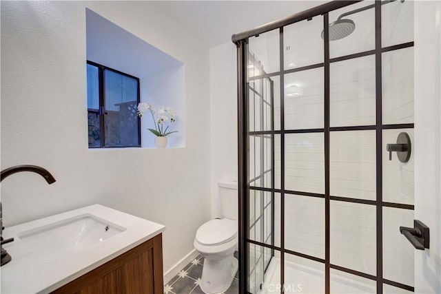 bathroom featuring a tile shower, tile patterned flooring, vanity, and toilet