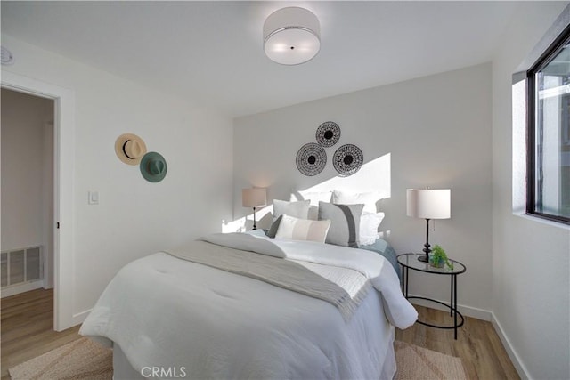 bedroom with light hardwood / wood-style flooring and multiple windows