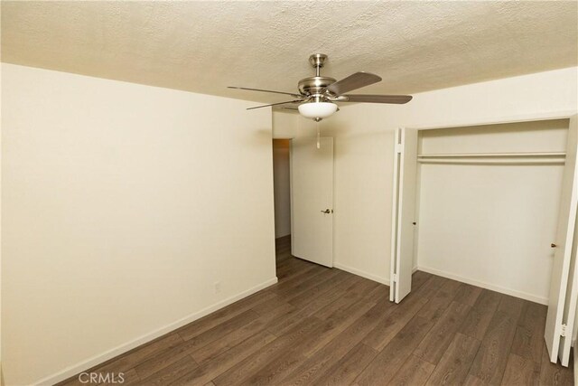 unfurnished bedroom with dark hardwood / wood-style floors, a textured ceiling, a closet, and ceiling fan