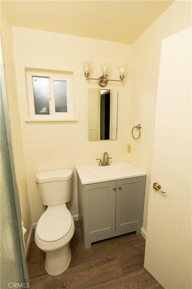 bathroom with vanity, hardwood / wood-style flooring, and toilet