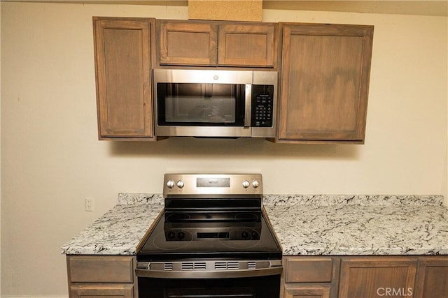 kitchen featuring appliances with stainless steel finishes and light stone countertops