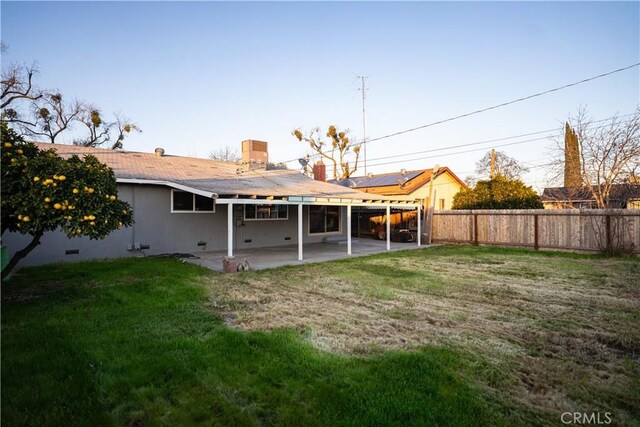 rear view of house with a patio and a lawn