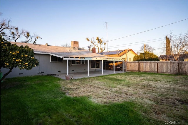 rear view of property with a patio and a lawn