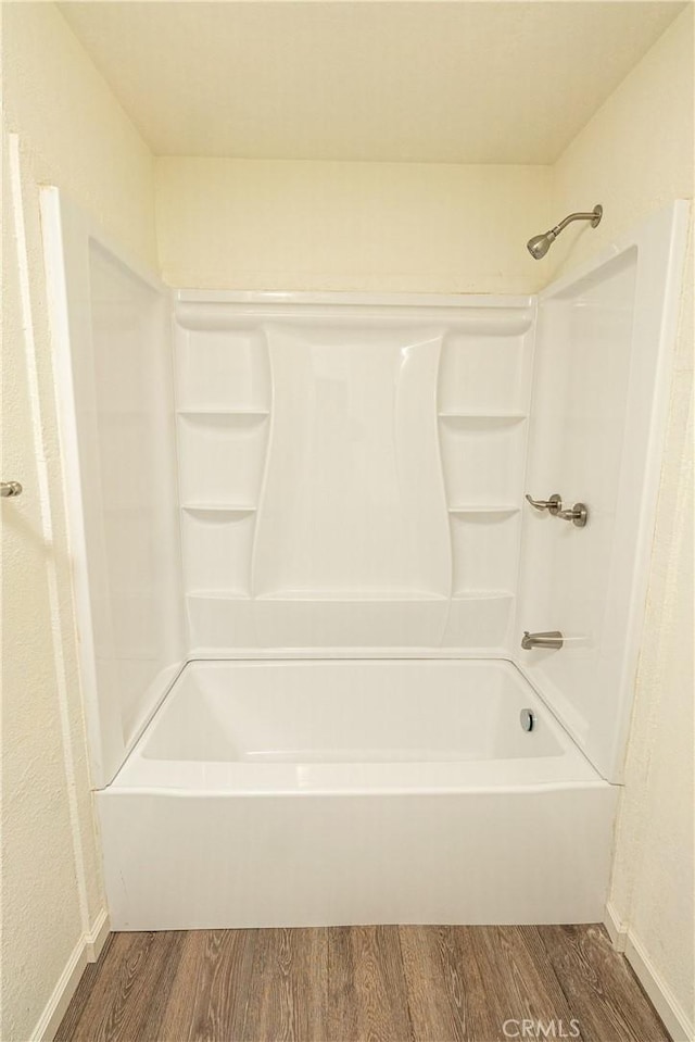 bathroom with hardwood / wood-style floors and bathtub / shower combination