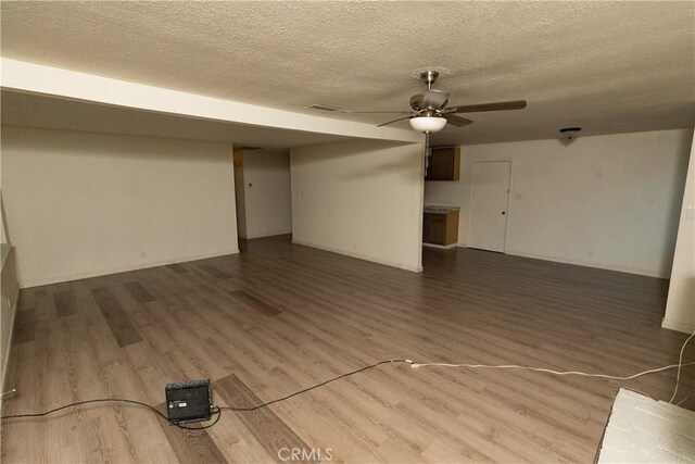 interior space featuring hardwood / wood-style flooring, ceiling fan, and a textured ceiling