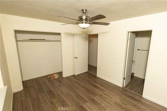 unfurnished bedroom with a textured ceiling, dark wood-type flooring, a closet, and ceiling fan