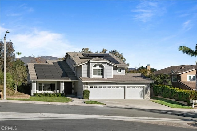 view of front property with solar panels, a garage, and a mountain view