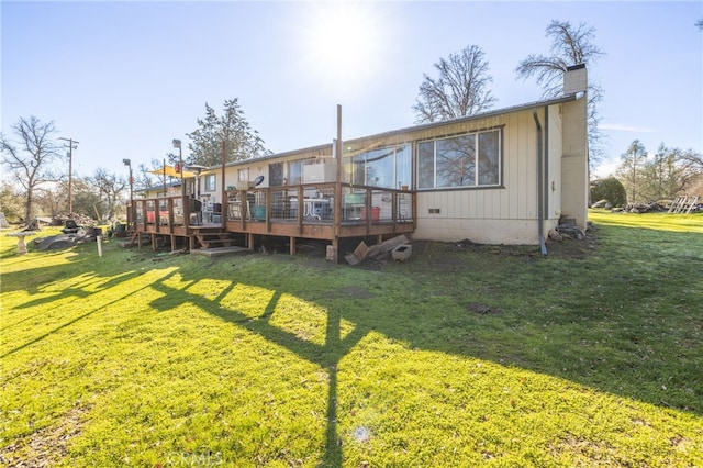 rear view of property with a lawn and a deck