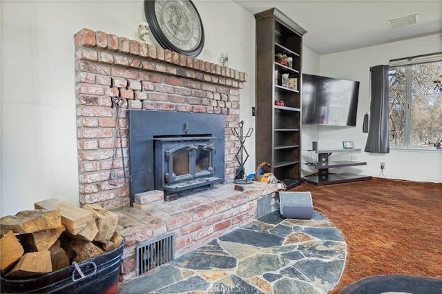 living room with carpet and a wood stove