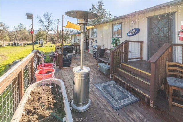 deck featuring a lawn and a grill