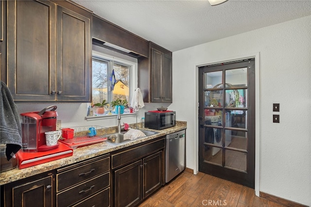 kitchen featuring dark wood-type flooring, dark brown cabinets, dishwasher, light stone counters, and sink