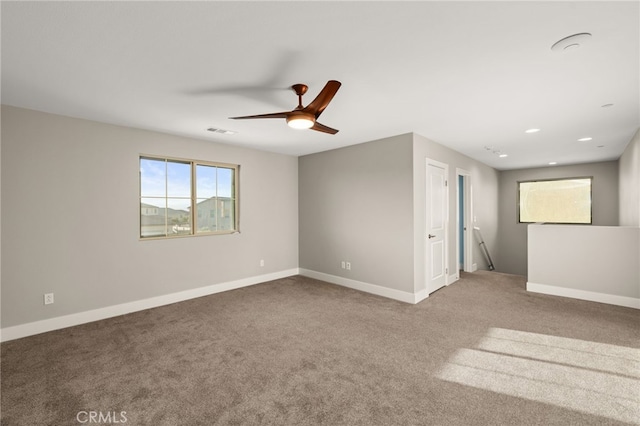 carpeted spare room featuring ceiling fan