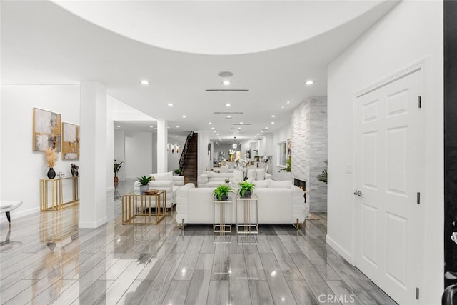 living area with recessed lighting, a large fireplace, baseboards, stairs, and wood tiled floor