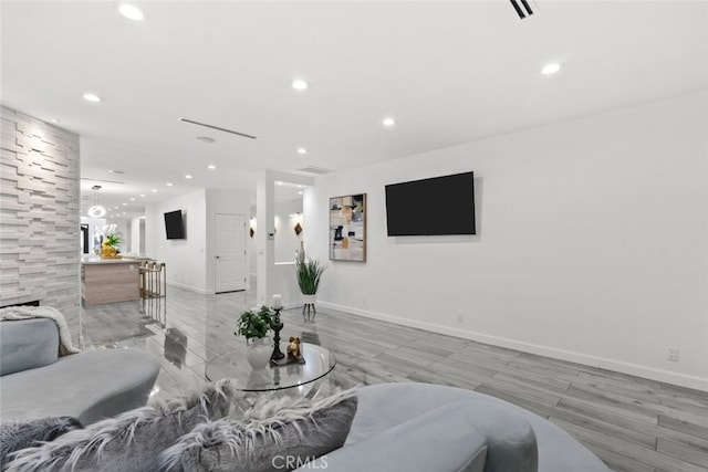 living area featuring baseboards, light wood-style floors, and recessed lighting