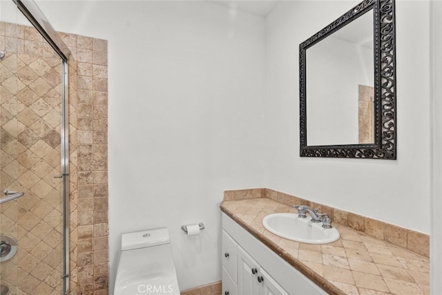 bathroom featuring toilet, a shower stall, and vanity