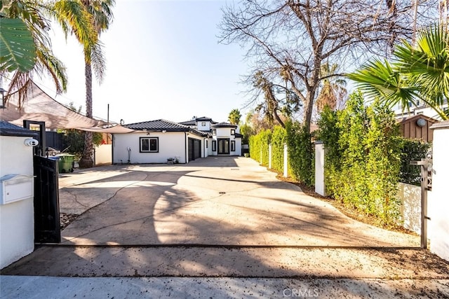 5157 Avenida Oriente, Tarzana, CA 91356 - view of front facade with concrete driveway, a garage, stucco siding, and a tiled roof